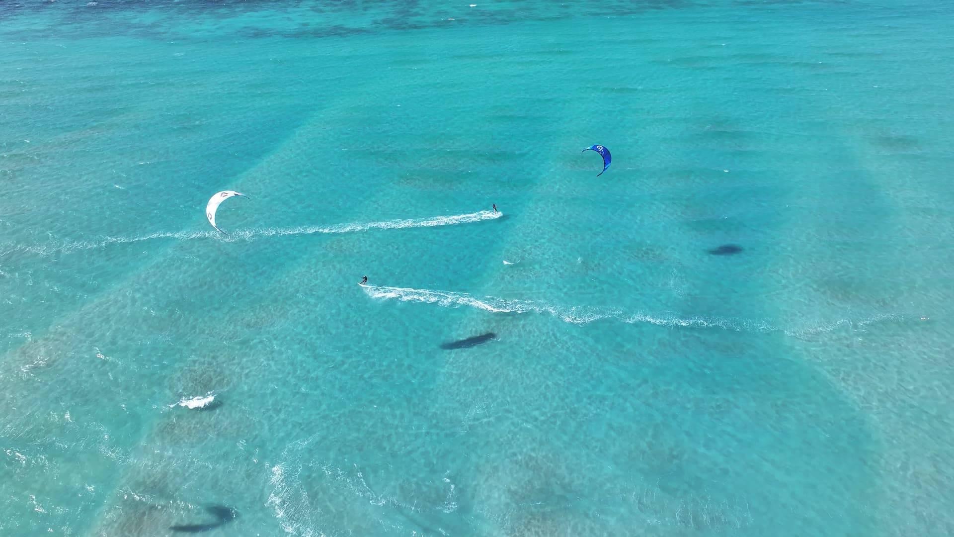 A kitesurfer throwing a peace sign in the shallow turquoise lagoon at Soul, Ras Sudr